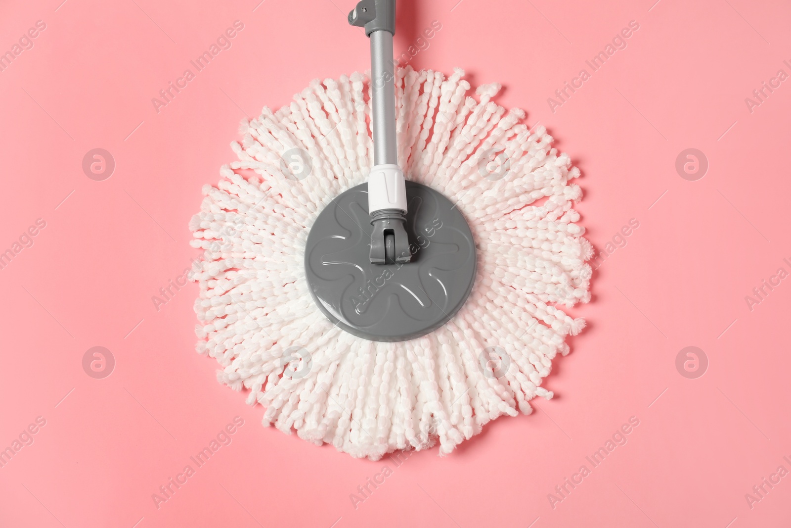 Photo of String mop on pink background, above view