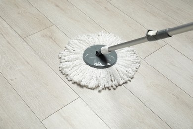 String mop on wooden floor. Cleaning equipment