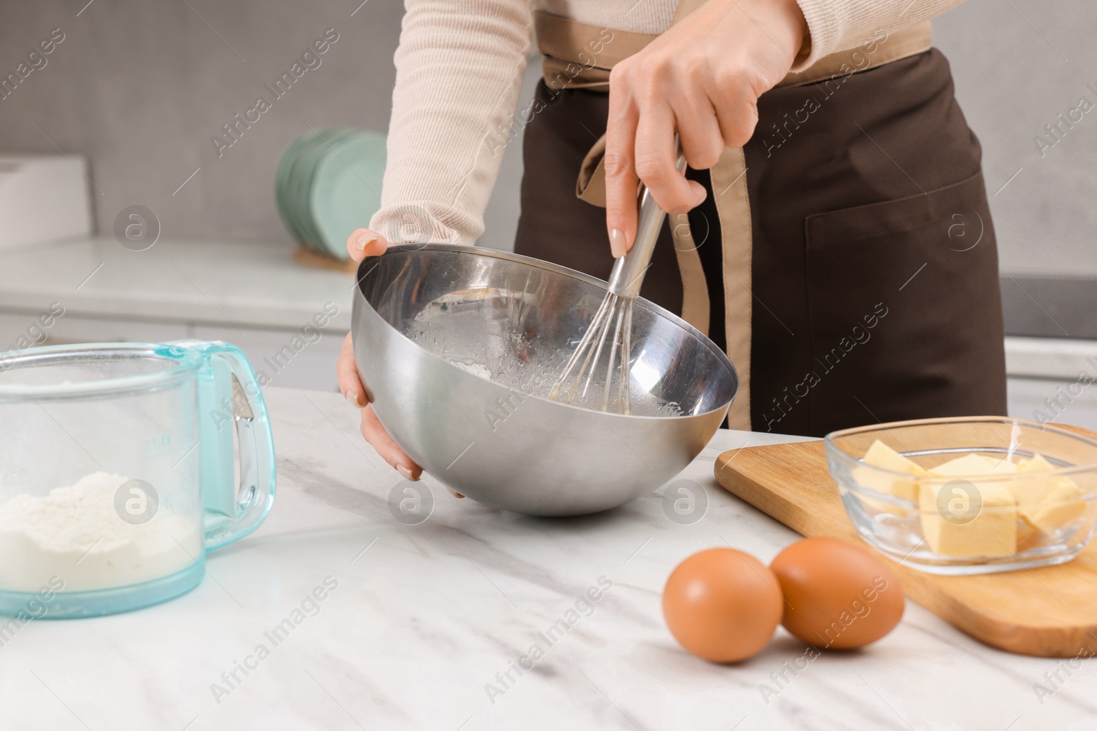 Photo of Woman making dough at white marble table indoors, closeup