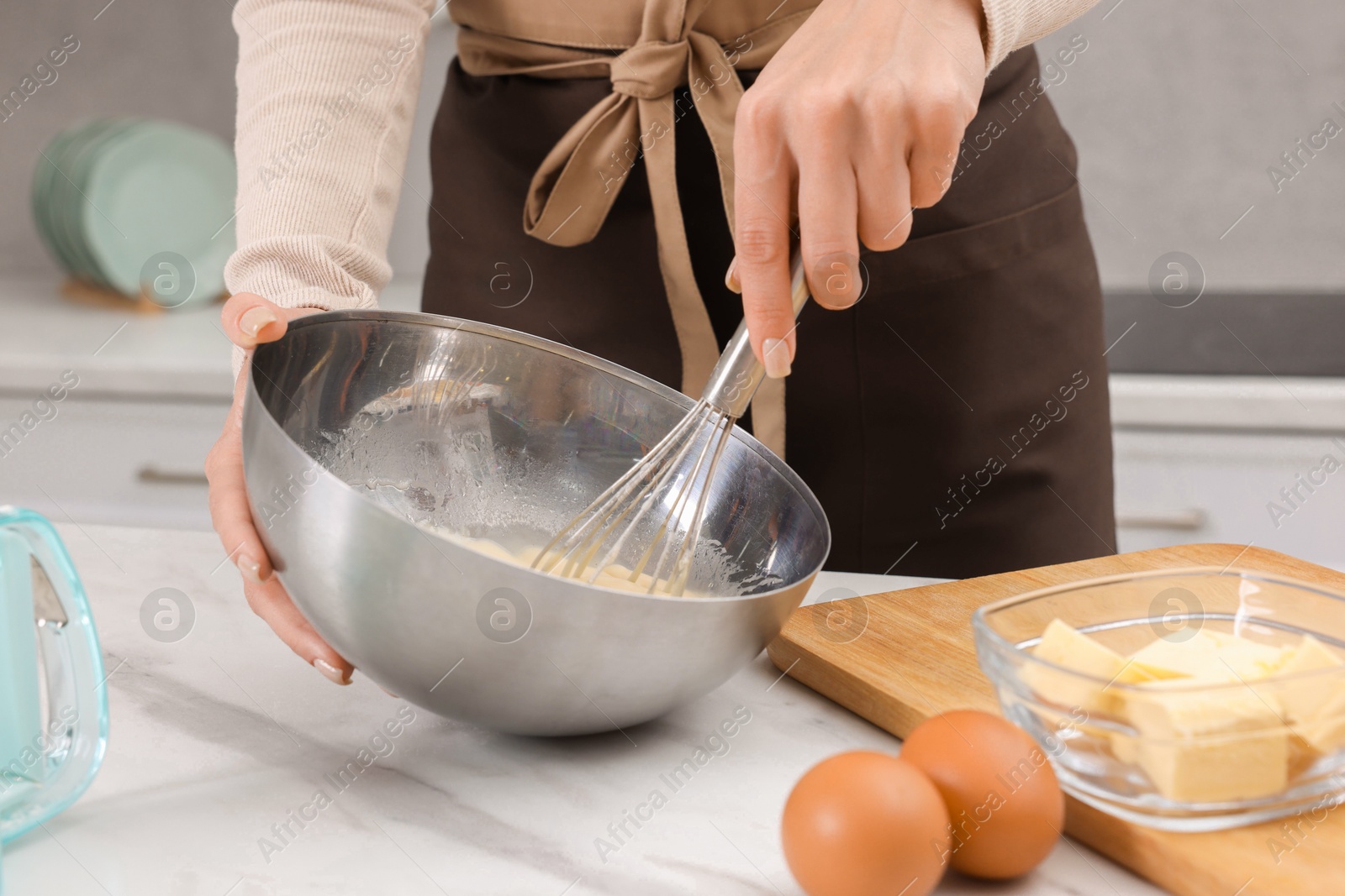 Photo of Woman making dough at white marble table indoors, closeup