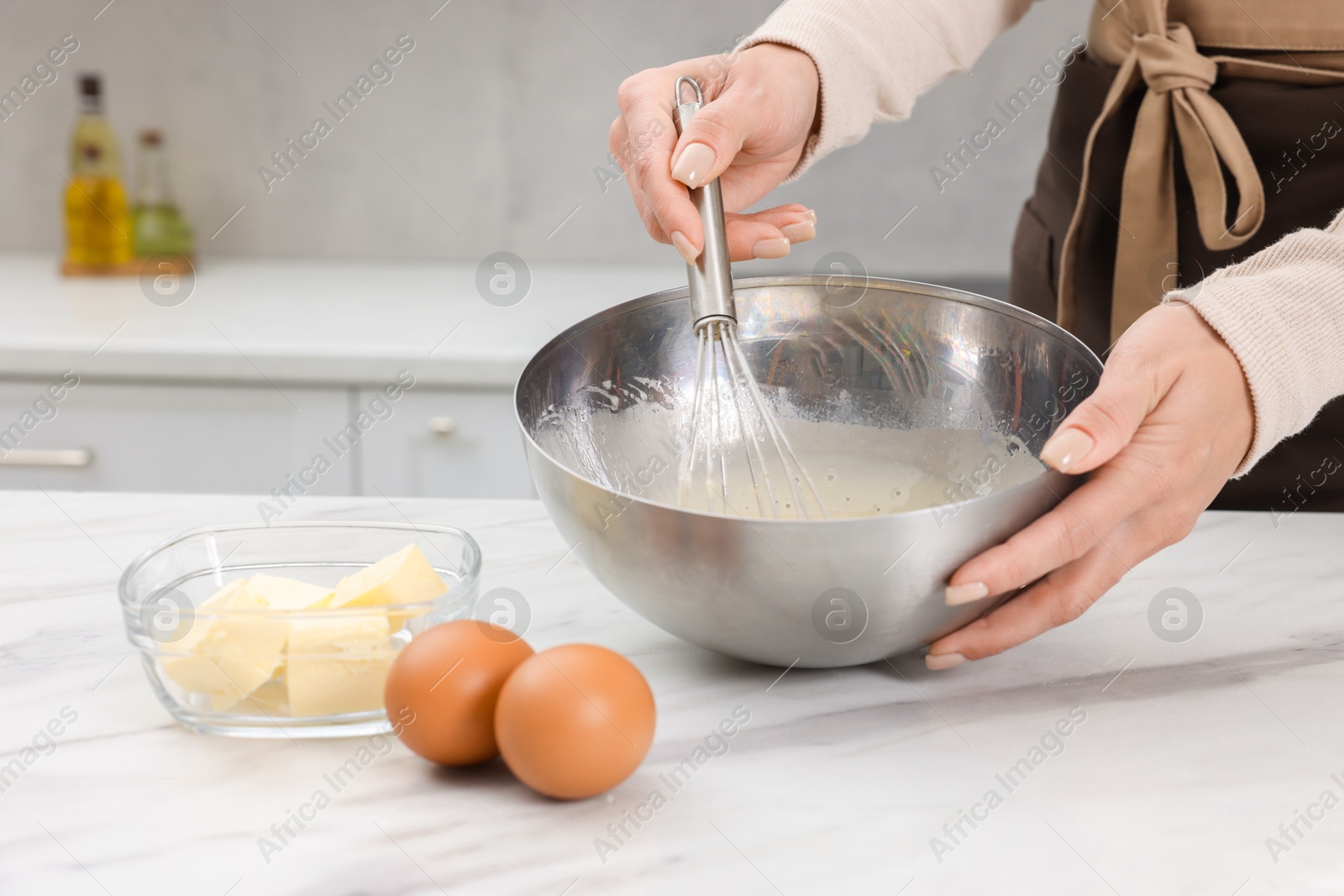 Photo of Woman making dough at white marble table indoors, closeup. Space for text