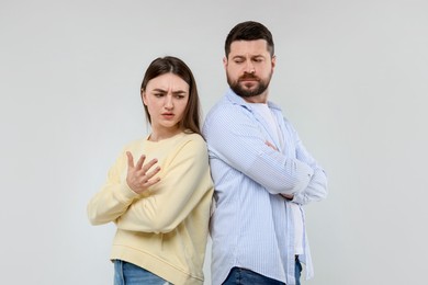 Photo of Resentful couple on light grey background. Relationship problem