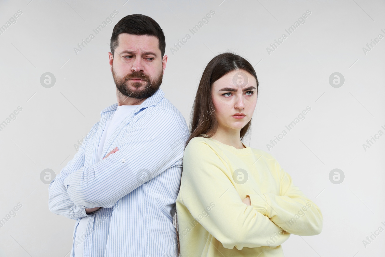 Photo of Resentful couple with crossed arms on light grey background