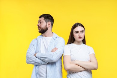 Photo of Resentful couple with crossed arms on yellow background