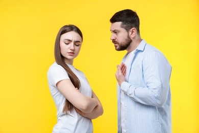 Photo of Angry couple arguing on yellow background. Relationship problem