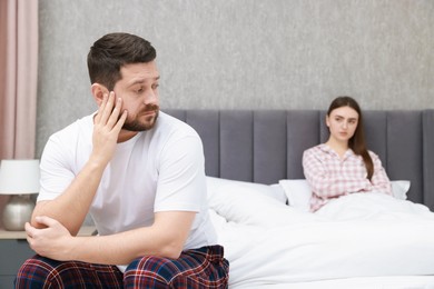 Photo of Resentful couple on bed at home, selective focus