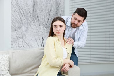 Man comforting his resentful girlfriend at home