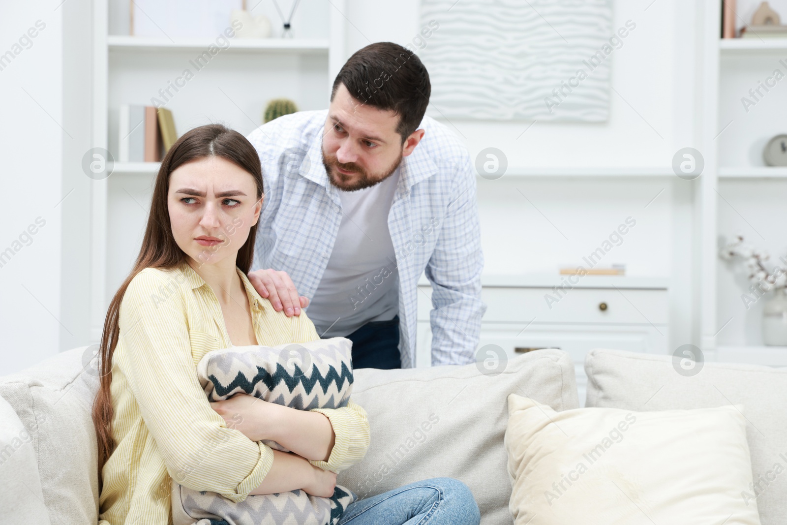 Photo of Man comforting his resentful girlfriend at home, space for text