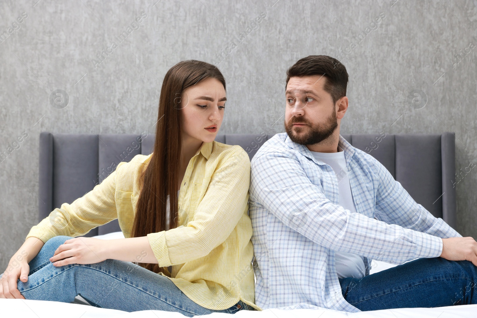 Photo of Resentful couple sitting on bed at home. Relationship problem