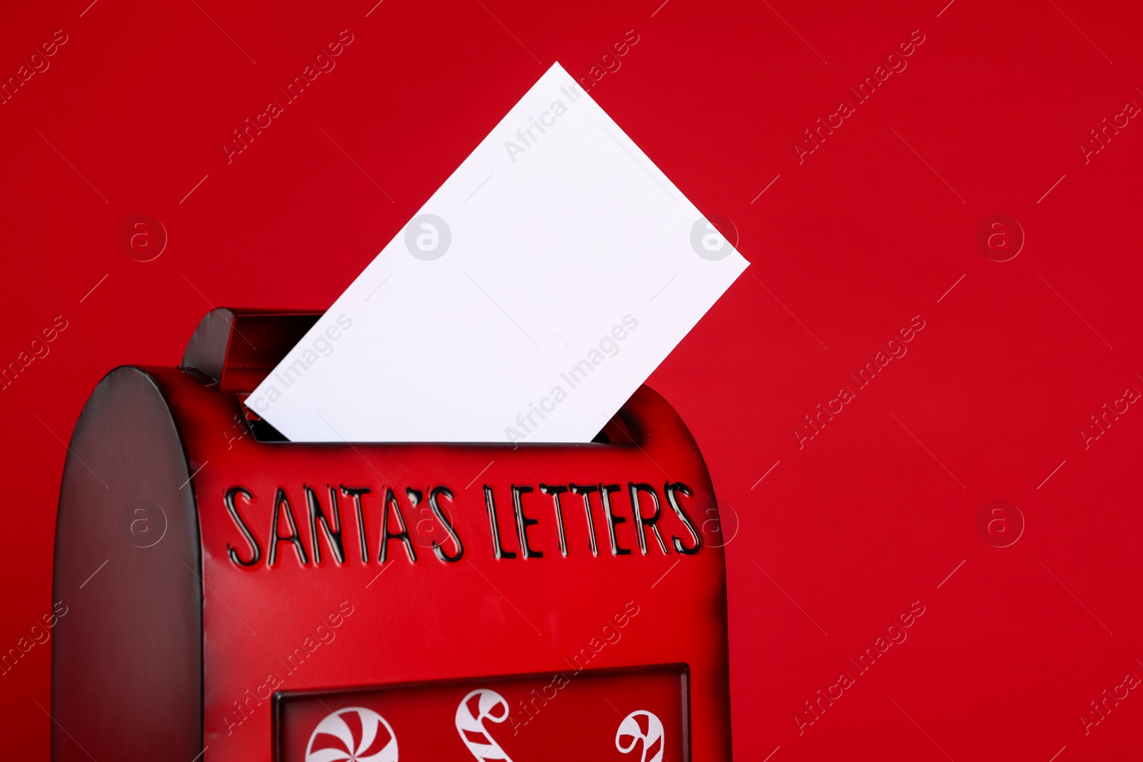 Photo of Santa Claus mailbox with letter on red background, closeup with space for text. Christmas tradition