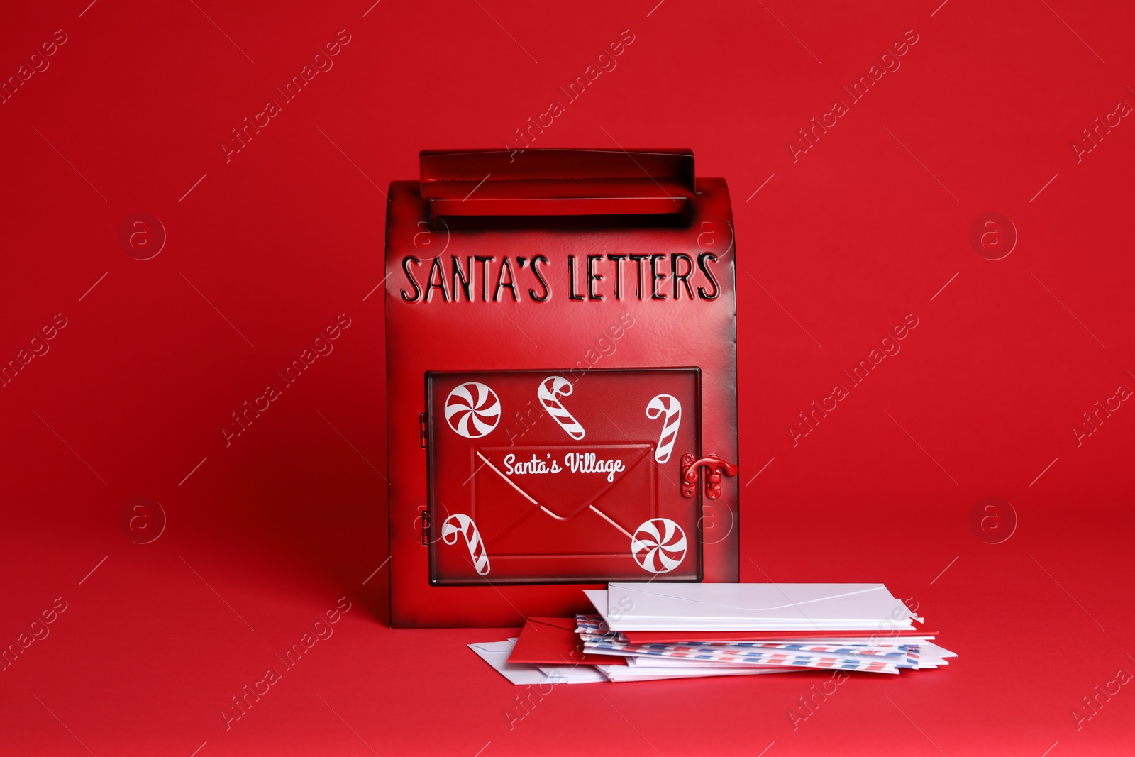 Photo of Santa Claus mailbox and letters on red background. Christmas tradition