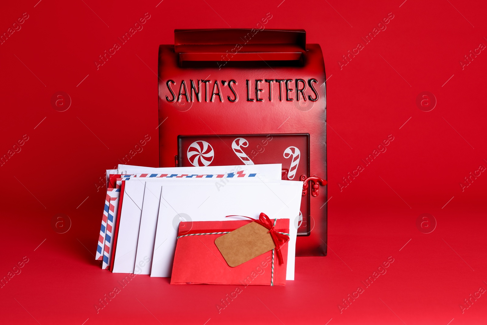 Photo of Santa Claus mailbox and letters on red background. Christmas tradition