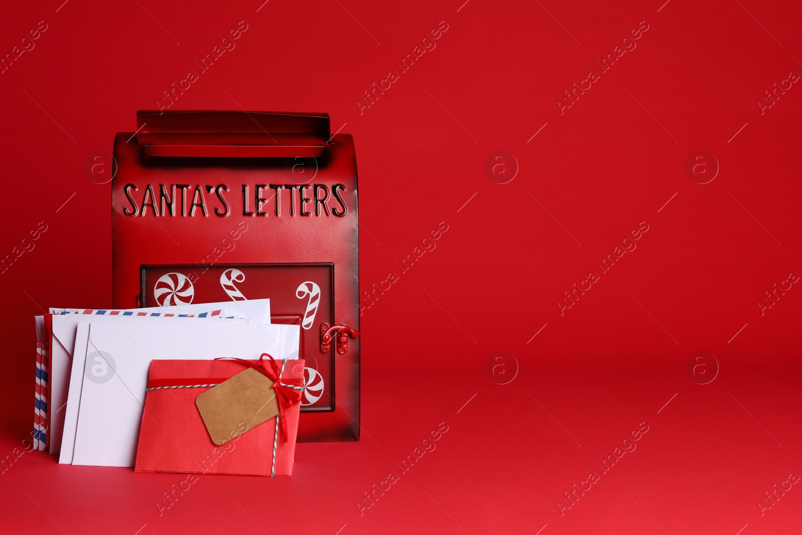 Photo of Santa Claus mailbox and letters on red background, space for text. Christmas tradition