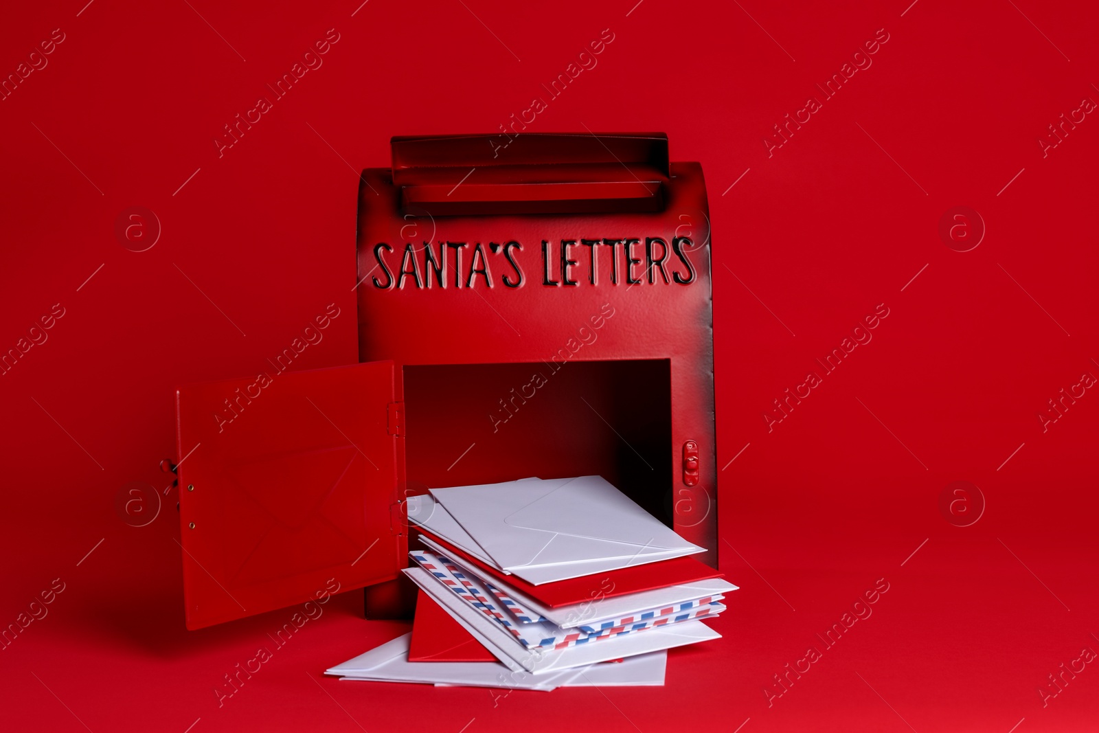 Photo of Open Santa Claus mailbox with letters on red background. Christmas tradition