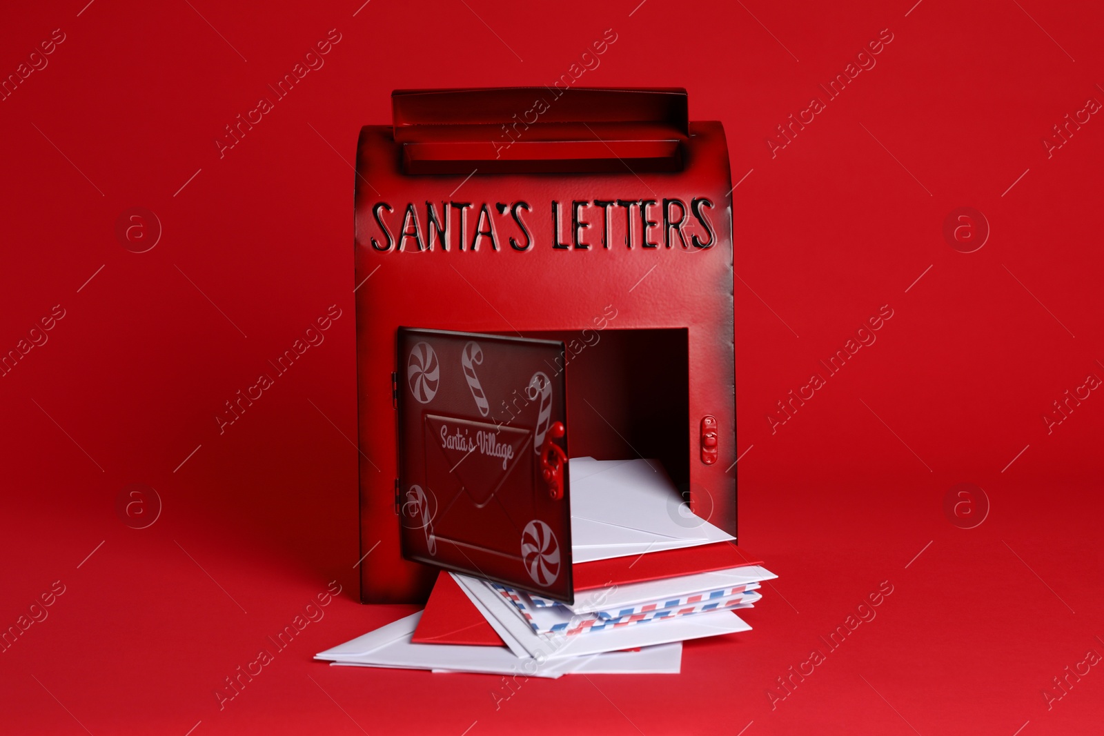 Photo of Open Santa Claus mailbox with letters on red background. Christmas tradition