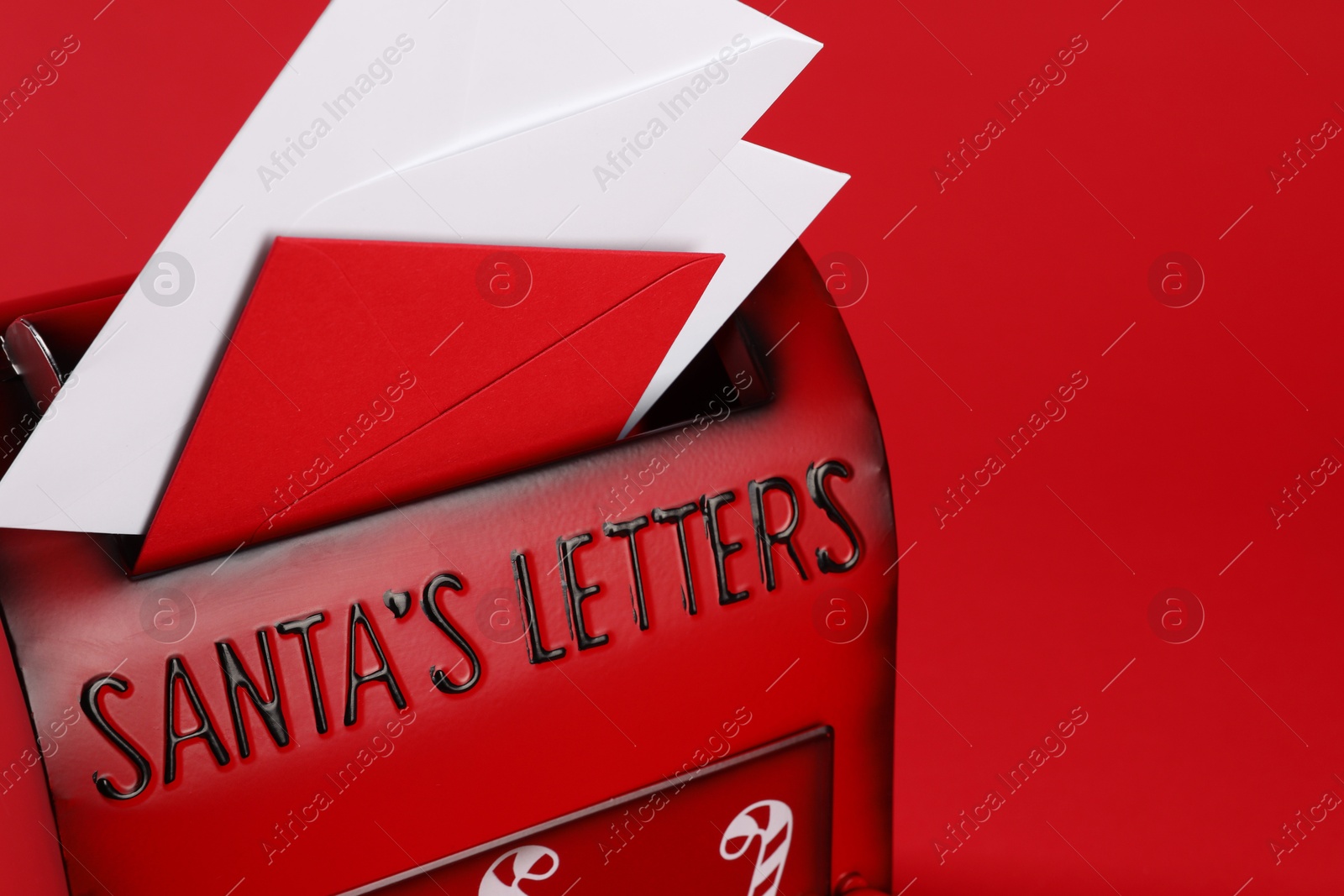 Photo of Santa Claus mailbox with letters on red background, closeup with space for text. Christmas tradition