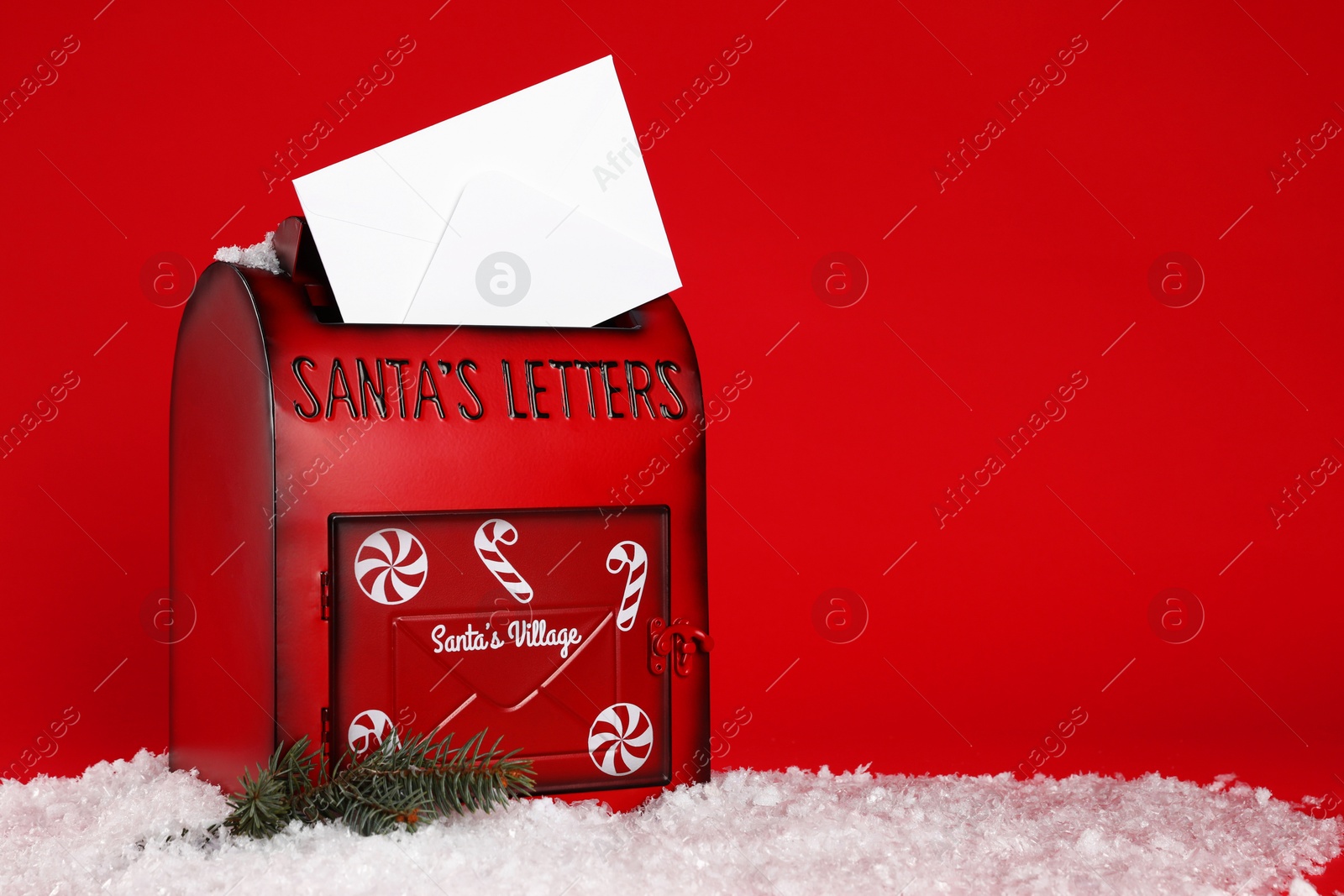 Photo of Santa Claus mailbox with envelope, fir tree branch and artificial snow on red background, space for text. Christmas tradition