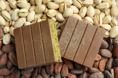 Photo of Pieces of tasty Dubai chocolate with knafeh, pistachios and cocoa beans, top view