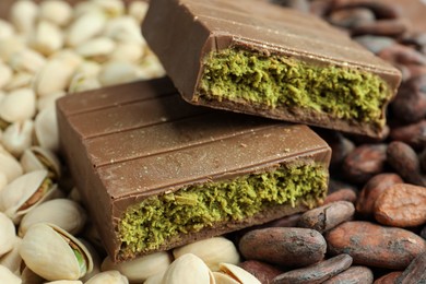 Photo of Pieces of tasty Dubai chocolate with knafeh, pistachios and cocoa beans, closeup