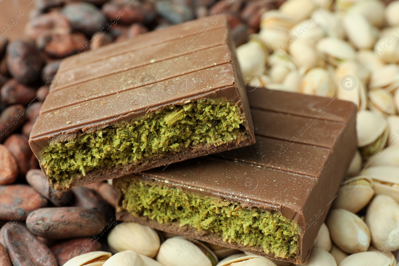 Photo of Pieces of tasty Dubai chocolate with knafeh, pistachios and cocoa beans, closeup