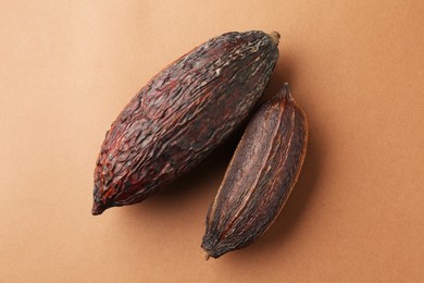 Cocoa pods on brown background, top view