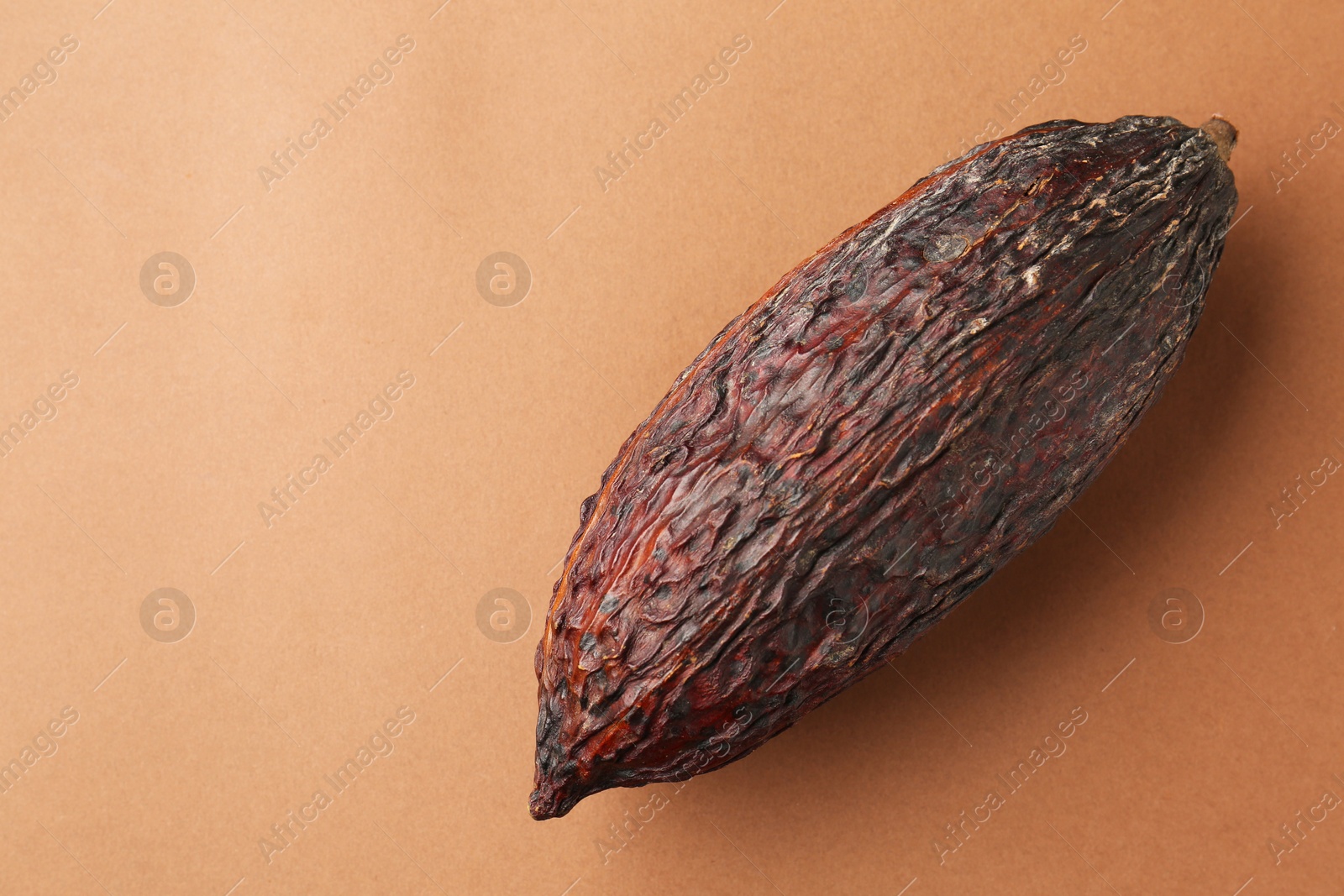 Cocoa pod on brown background, top view. Space for text Photo of Cocoa pod on brown background, top view. Space for text