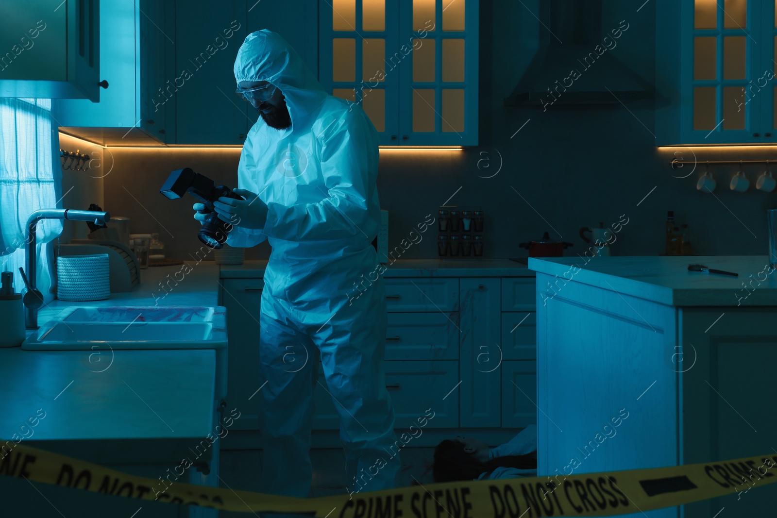 Photo of Forensic expert with camera working at crime scene in dark room