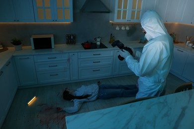 Photo of Forensic expert with camera working at crime scene and dead woman's body in dark room