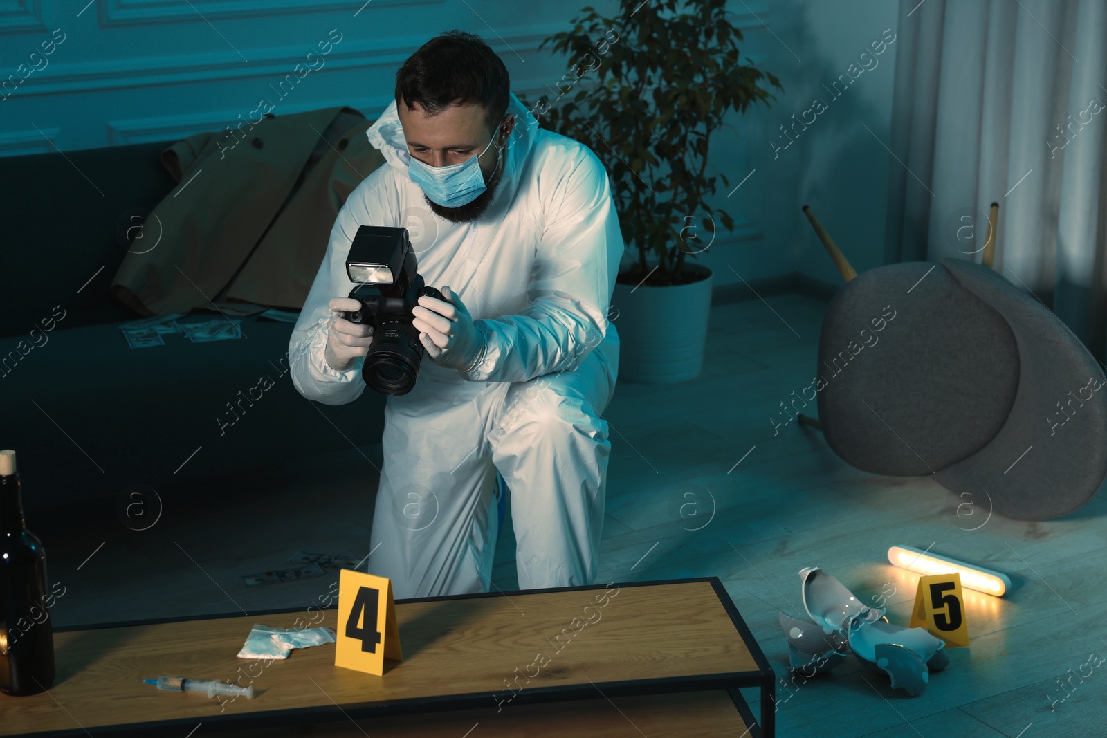 Photo of Forensic expert with camera taking photo of evidences at crime scene indoors