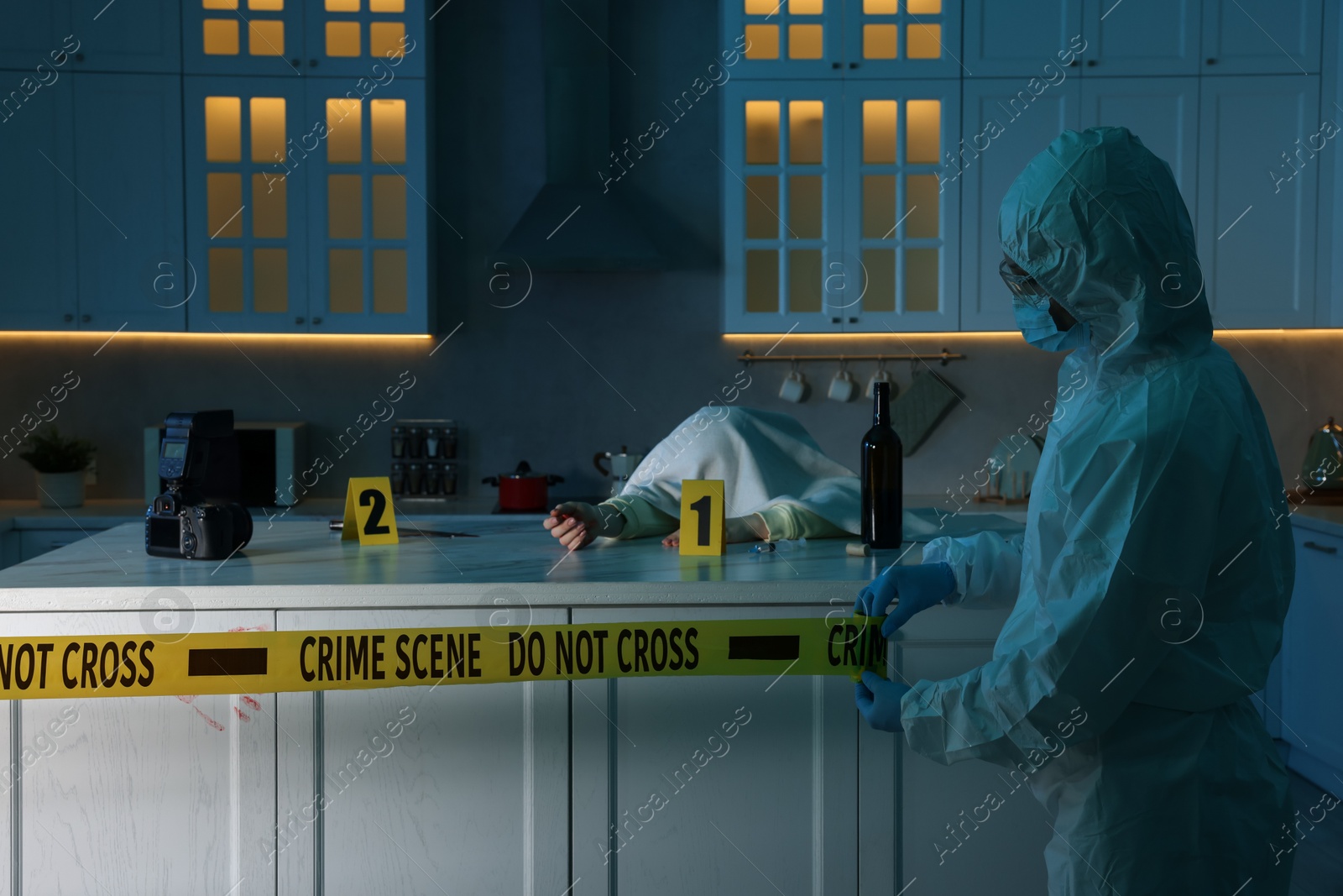 Photo of Forensic expert blocking way to crime scene and dead body with yellow tape indoors