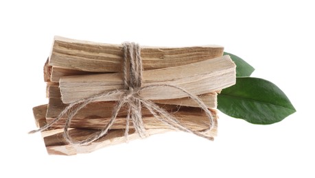 Photo of Palo santo sticks and green leaves on white background