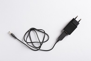 Photo of USB power adapter with charge cable on white background, top view