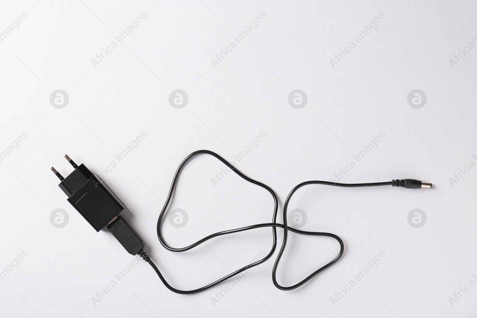 Photo of USB power adapter with charge cable on white background, top view