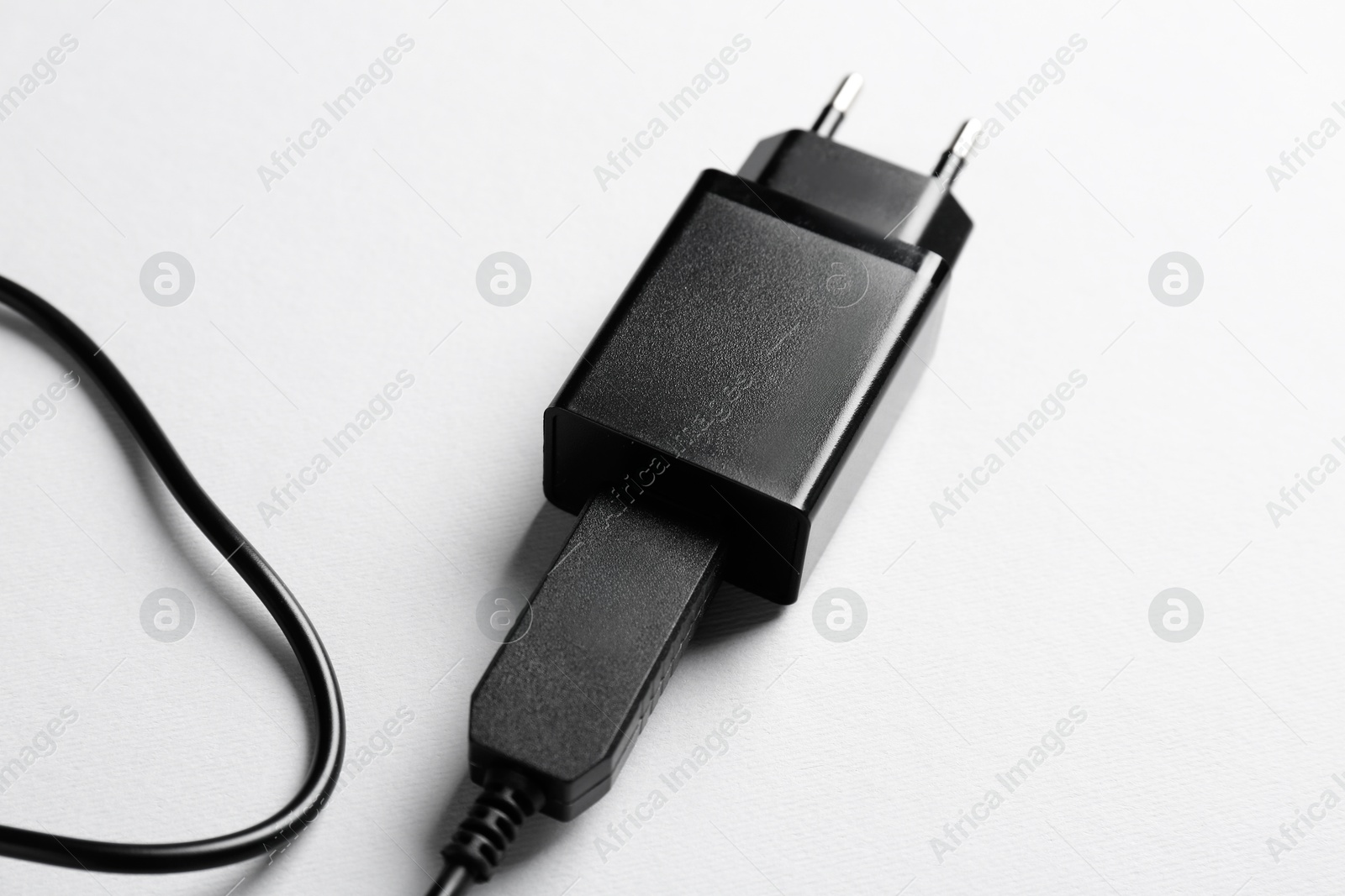 Photo of USB power adapter with charge cable on white background, closeup