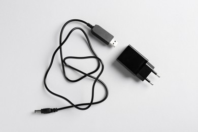 Photo of USB power adapter and charge cable on white background, flat lay