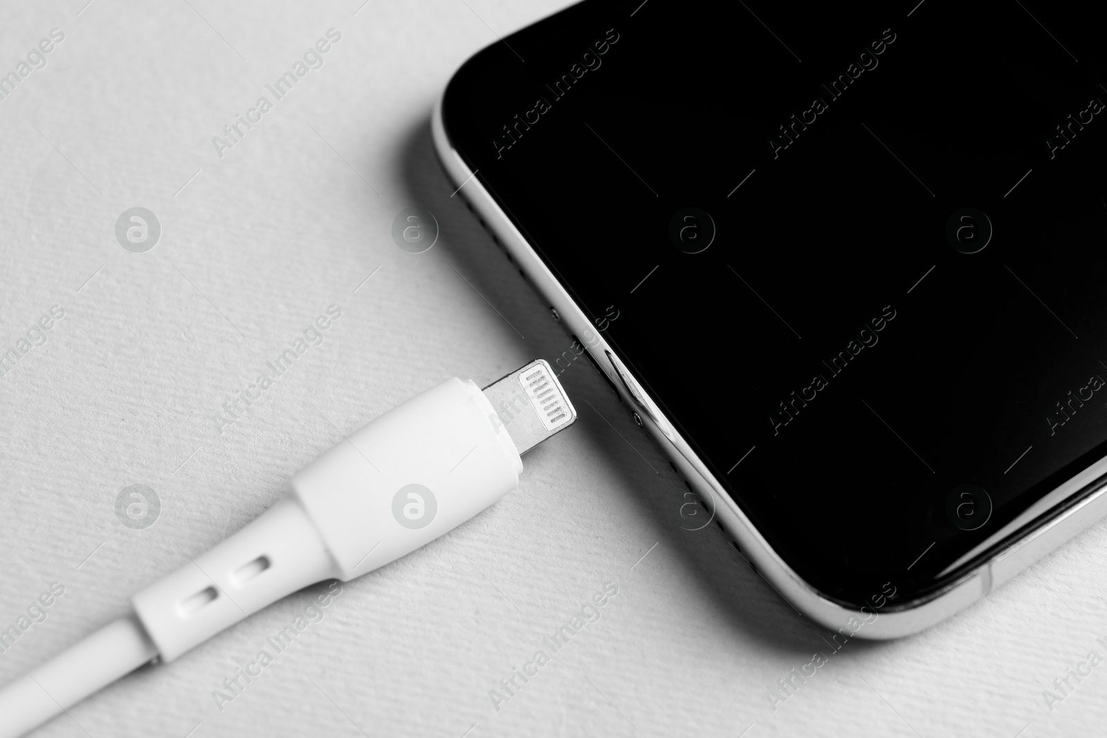 Photo of USB charge cable and smartphone on white background, closeup