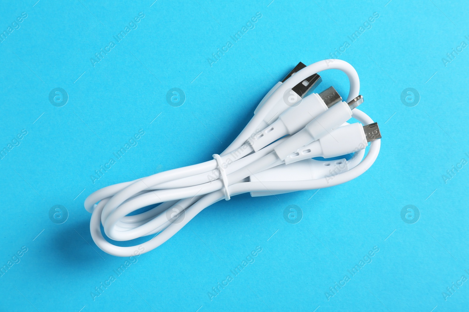 Photo of Triple charge cable on light blue background, top view