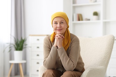 Senior woman with cancer on armchair at home