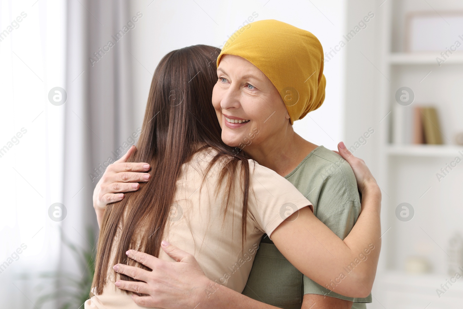 Photo of Woman with cancer and her daughter hugging at home