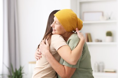 Photo of Woman with cancer and her daughter hugging at home