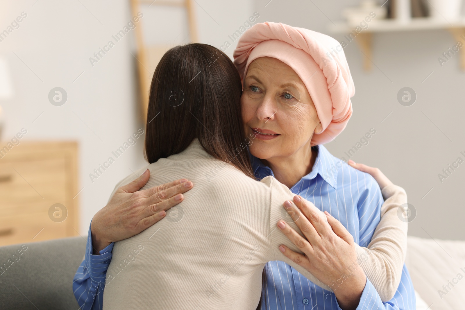 Photo of Woman with cancer and her daughter hugging at home