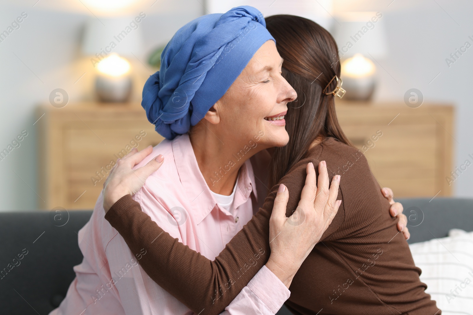 Photo of Woman with cancer and her daughter hugging at home