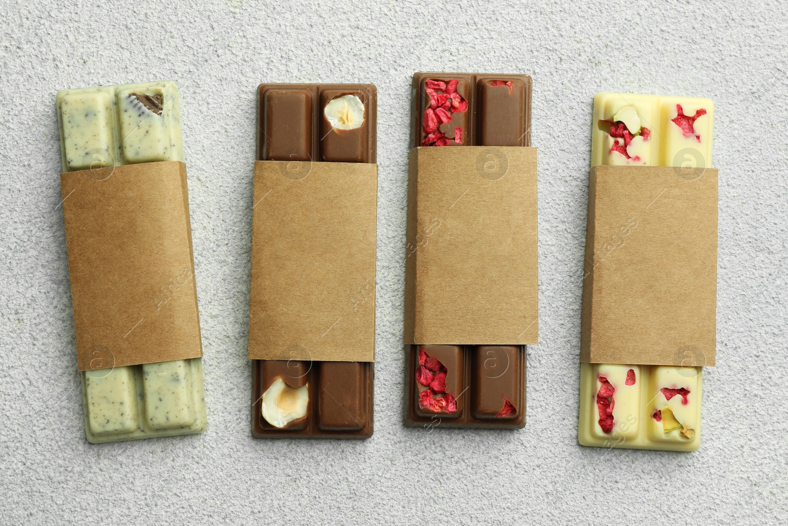 Photo of Delicious chocolate bars with different flavors on light table, flat lay