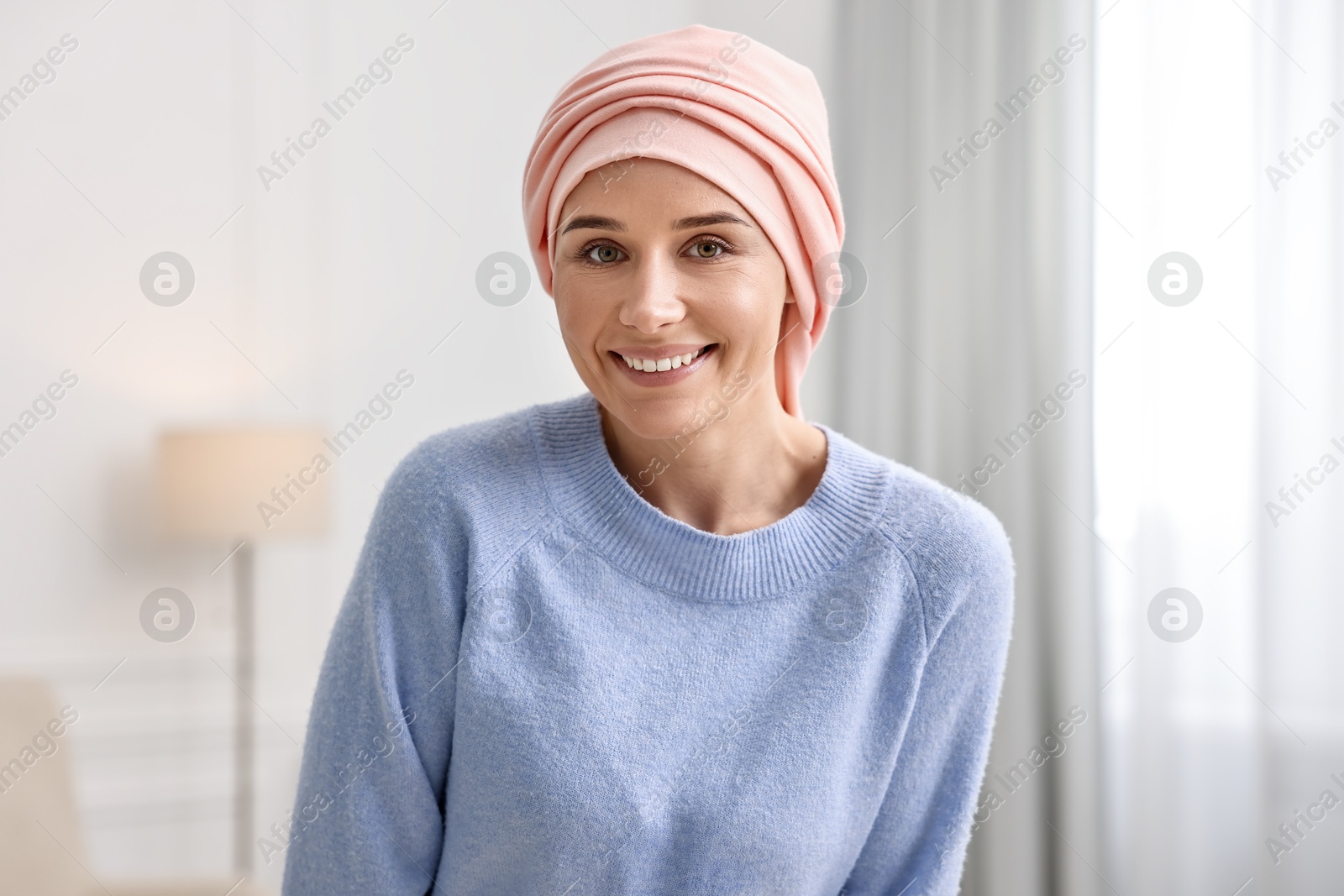 Photo of Portrait of smiling woman with cancer in headscarf indoors