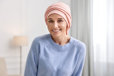 Photo of Portrait of smiling woman with cancer in headscarf indoors