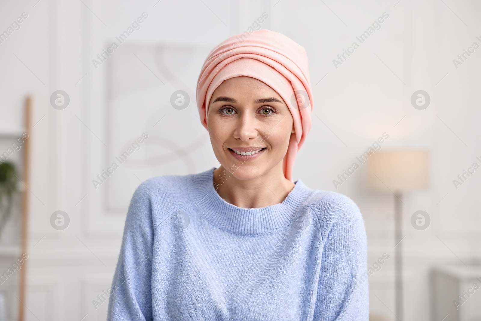 Photo of Portrait of smiling woman with cancer in headscarf indoors