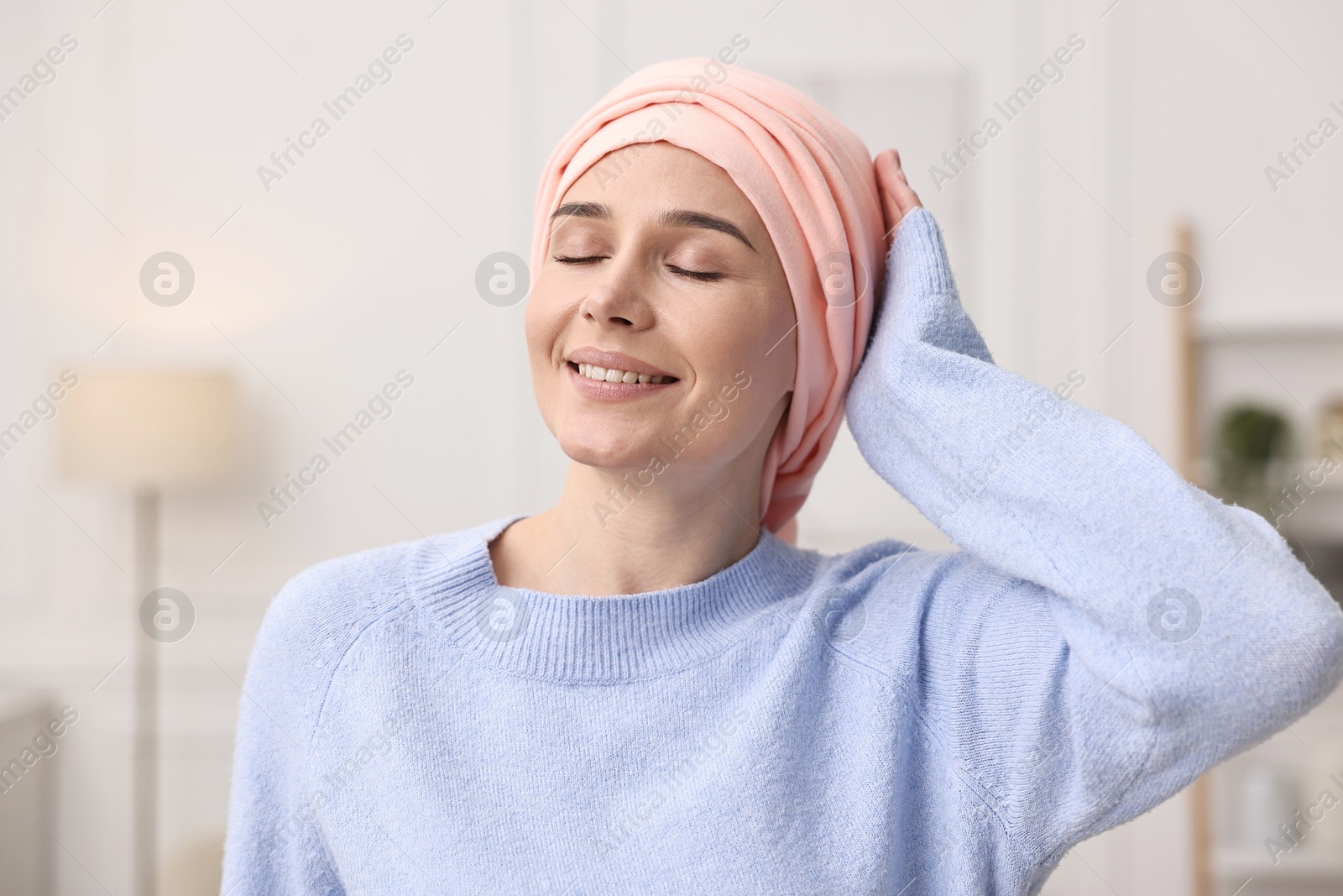 Photo of Portrait of smiling woman with cancer in headscarf indoors