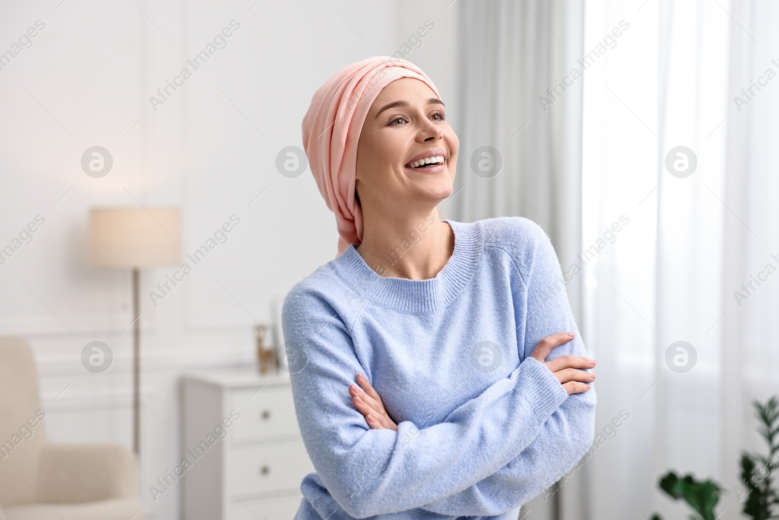 Photo of Portrait of smiling woman with cancer in headscarf indoors