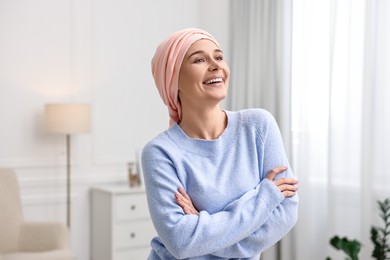 Photo of Portrait of smiling woman with cancer in headscarf indoors