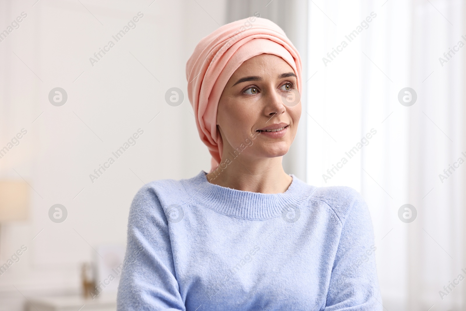 Photo of Portrait of smiling woman with cancer in headscarf indoors